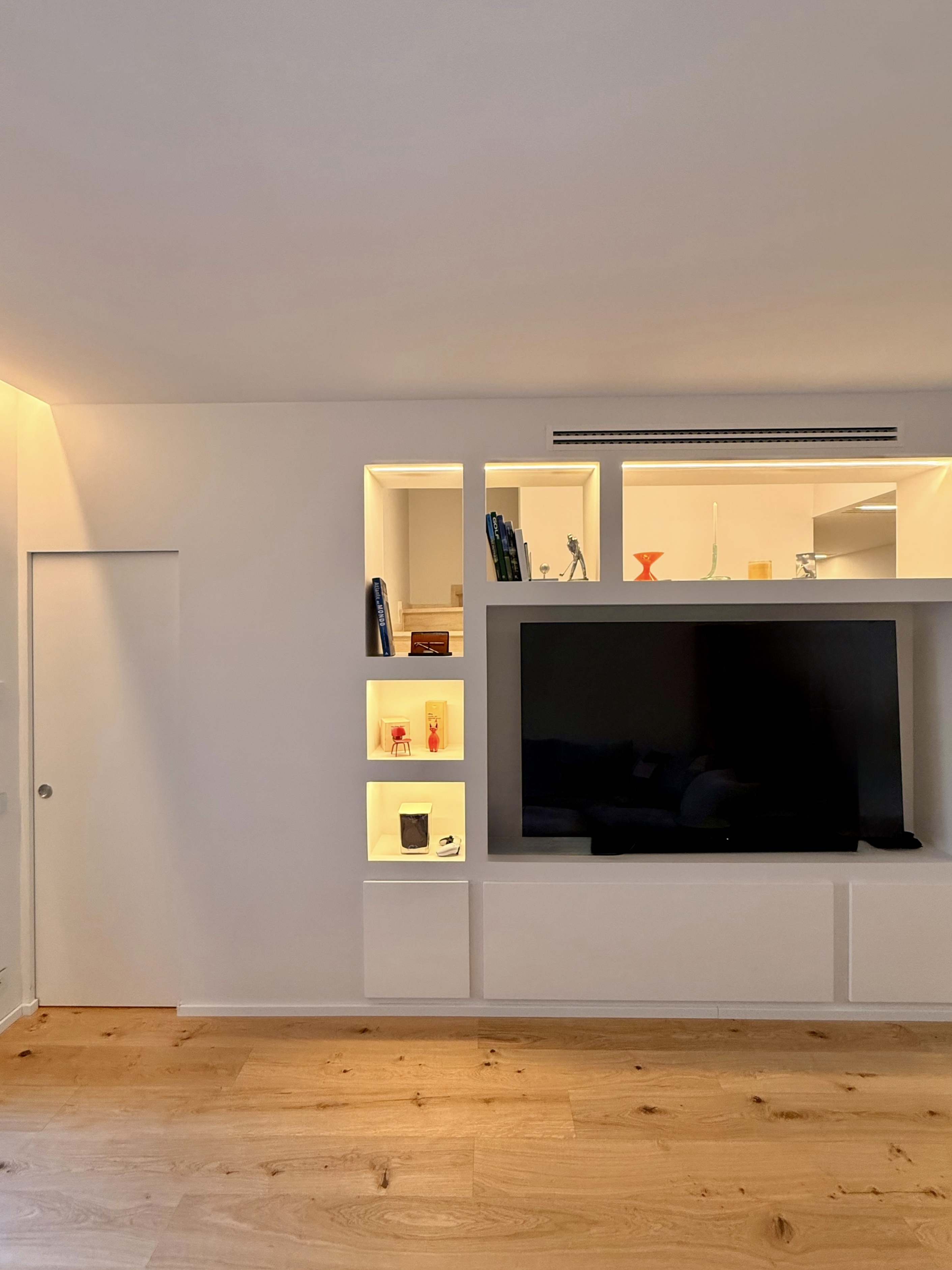 Parete attrezzata bianca con TV, nicchie e luci a led